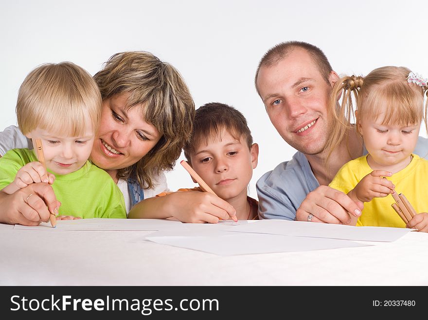 Happy family drawing at the table on a white. Happy family drawing at the table on a white