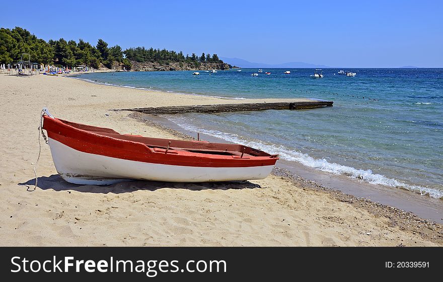 Red boat on calm beach