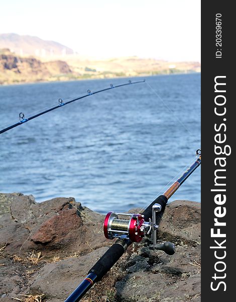 Two fishing poles. Columbia River with rocks in foreground. Extreme shallow depth of field with selective focus. Two fishing poles. Columbia River with rocks in foreground. Extreme shallow depth of field with selective focus.