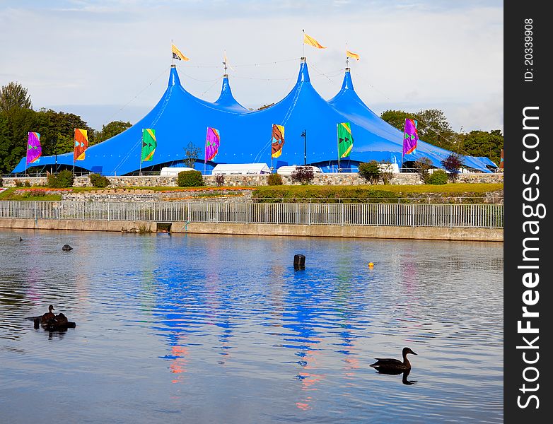Circus style blue tent on the bank of the river