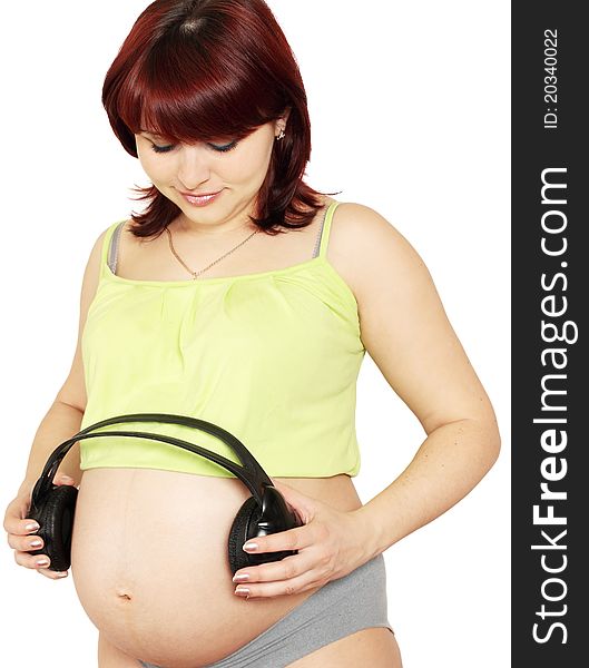 Pregnant woman holds head sets near the stomach