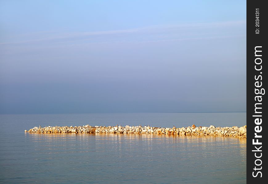 Stone embankment in the sea near the coast