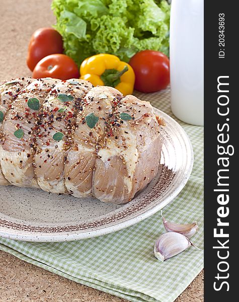 Country style stuffed meat with garlic and oregano leaves. Fresh vegetables on background. Country style stuffed meat with garlic and oregano leaves. Fresh vegetables on background.