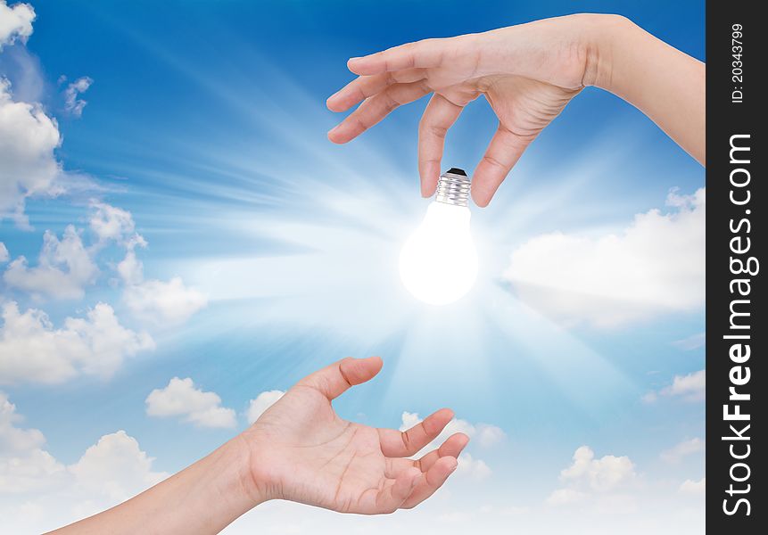 Business hand with Light bulb over blue sky. Business hand with Light bulb over blue sky.