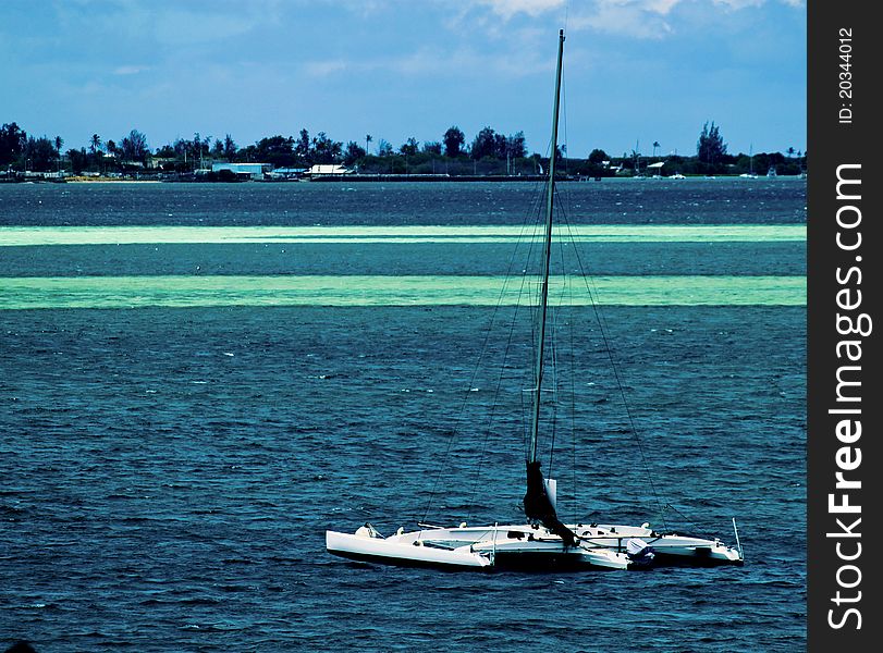 Catamaran floating in a sea of blues with the sanbar visible. Catamaran floating in a sea of blues with the sanbar visible