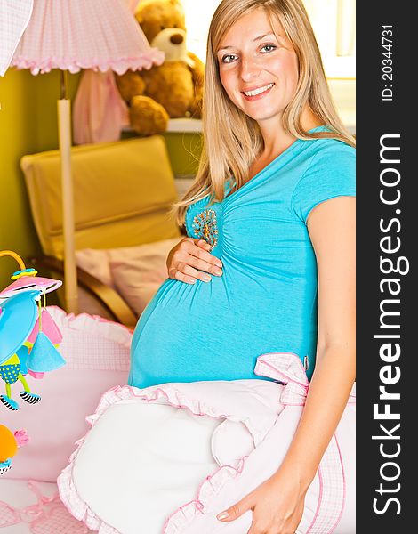 Pregnant woman in green and pink baby room. Pregnant woman in green and pink baby room