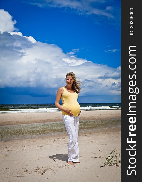 Pregnant woman on beach on a cloudy day