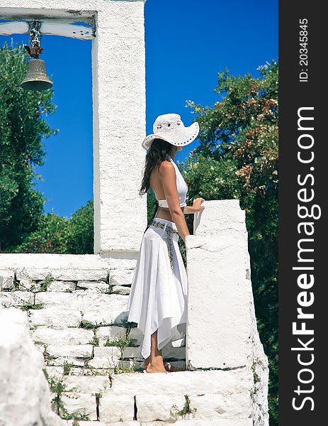 Young beautiful woman gazing in the distance from the stairs of an old church bell. Young beautiful woman gazing in the distance from the stairs of an old church bell