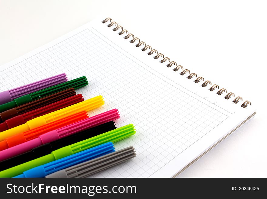 Markers on notebook isolated on white