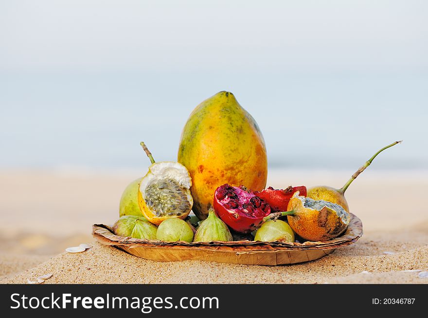 Exotic tropical fruit on the leaves plate, on the sandy beach. Exotic tropical fruit on the leaves plate, on the sandy beach