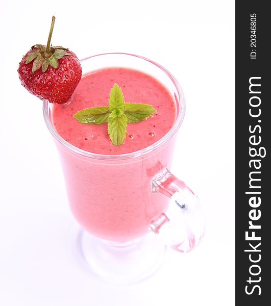 Strawberry shake in a glass decorated with a strawberry and mint