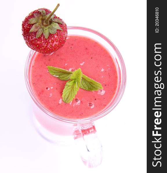 Strawberry shake in a glass decorated with a strawberry and mint