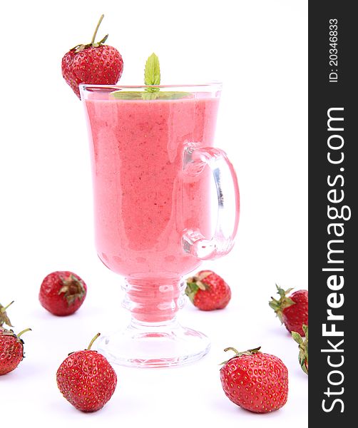 Strawberry shake in a glass decorated with strawberries and mint