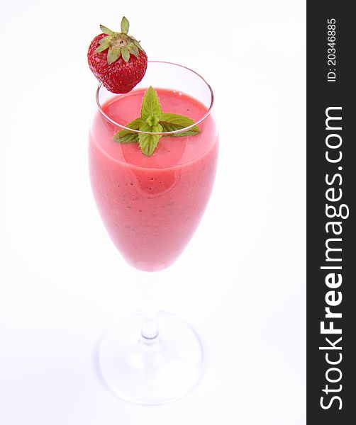 Strawberry shake in a champagne glass decorated with mint twig and a strawberry