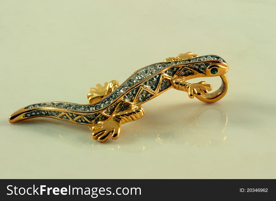 Jewelry in shape of lizard with stones on marble surface. Jewelry in shape of lizard with stones on marble surface