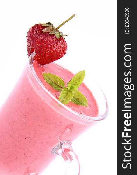Strawberry shake in a glass decorated with a strawberry and mint