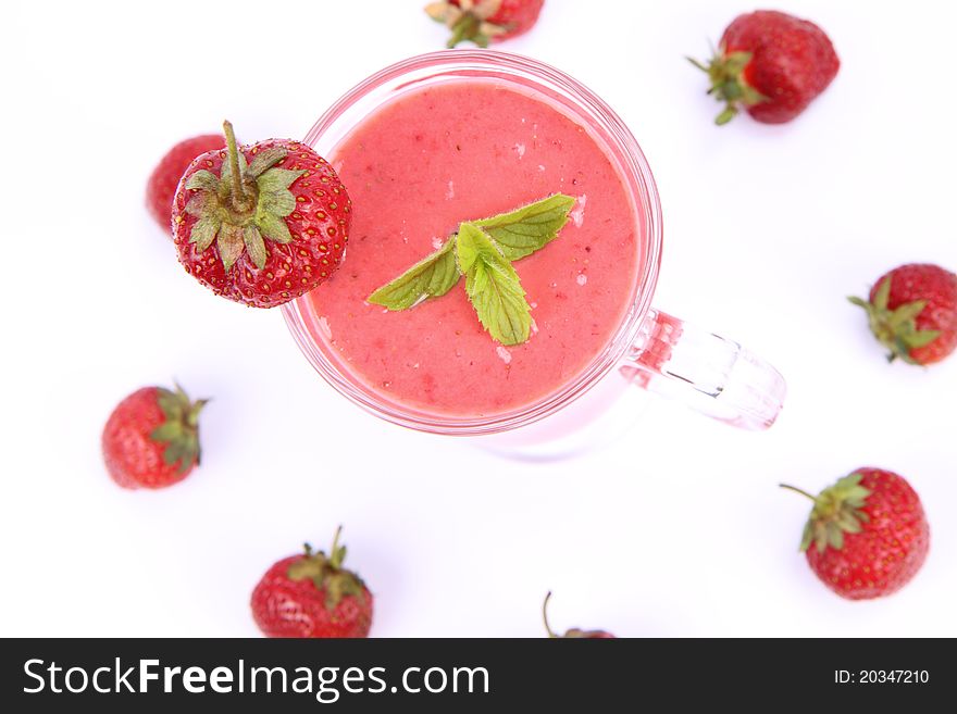 Strawberry shake in a glass decorated with strawberries and mint