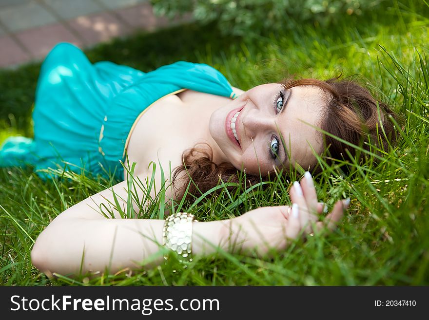 Pretty girl relaxing outdoor in green grass