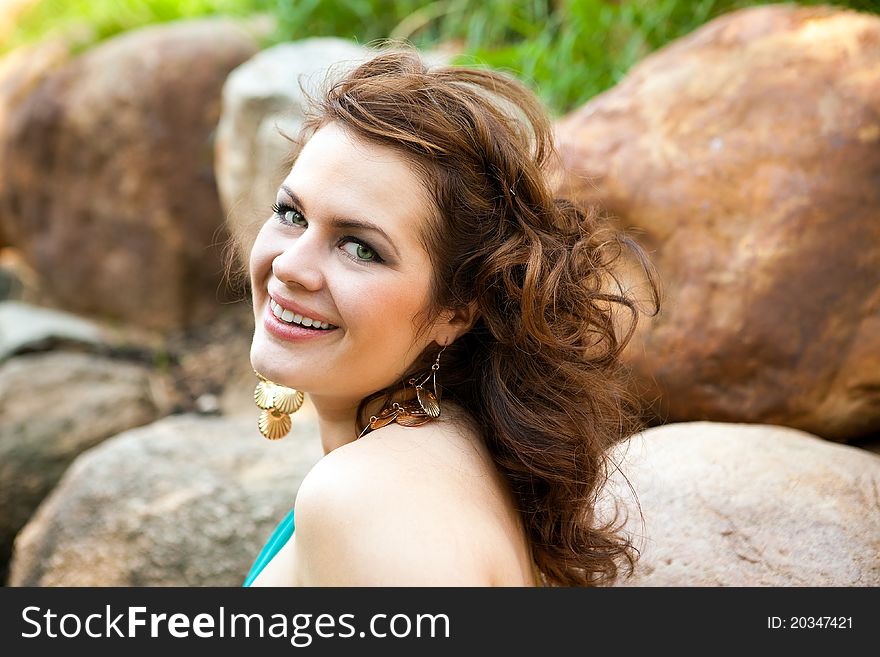 Girl with flowing hair on the background of rocks