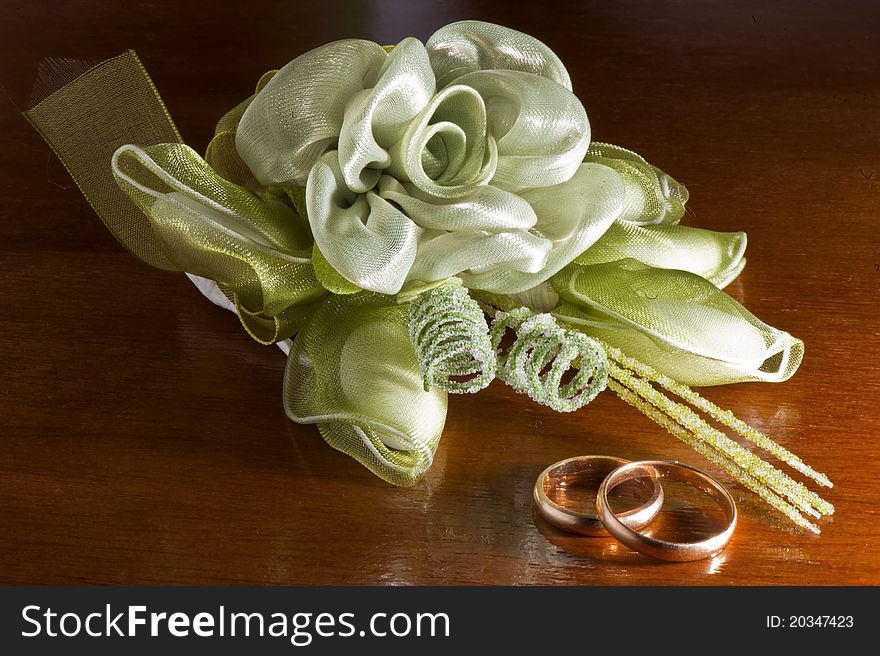 Wedding favors and wedding rings on a dark wood table