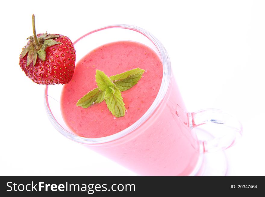 Strawberry shake in a glass decorated with a strawberry and mint