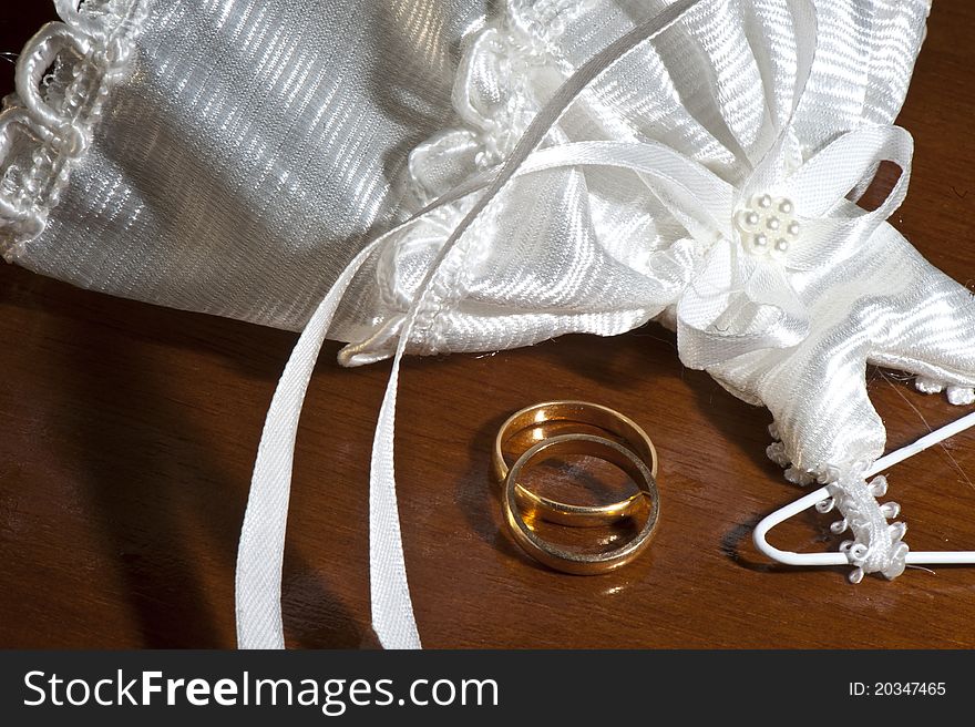 Wedding favors and wedding rings on a dark wood table