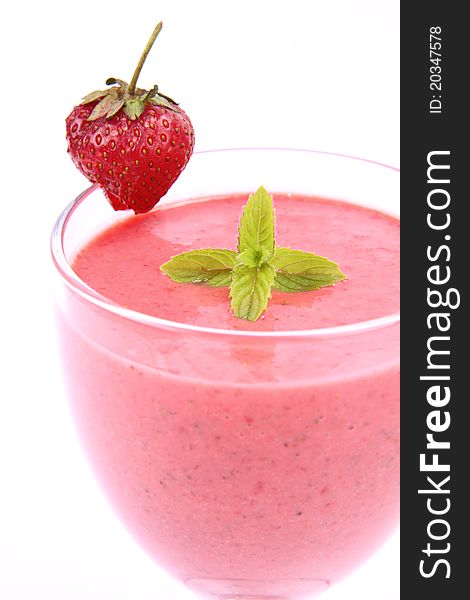 Strawberry shake in a glass decorated with a strawberry and mint