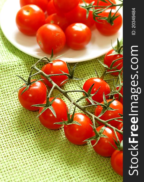 Cherry tomatoes on green background