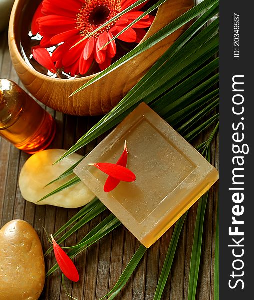 Spa composition of soap, stones and flowers on wooden