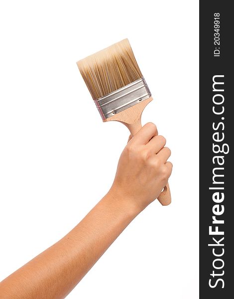 A feamle hand and arm holding a decorating brush. A feamle hand and arm holding a decorating brush