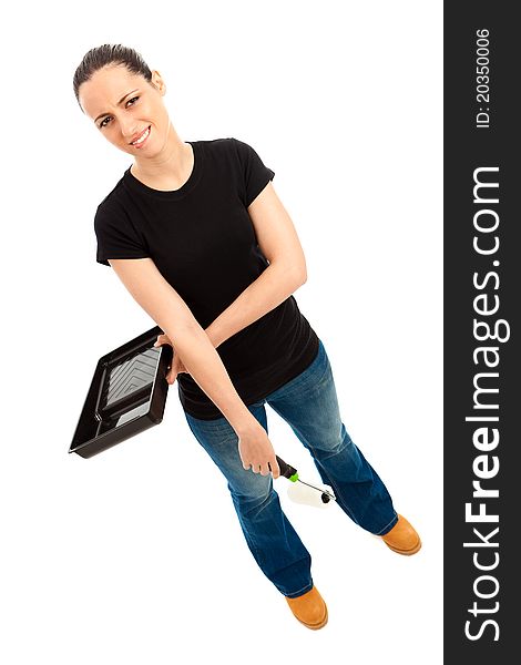 A young female dressed in a black t shirt and blue jeans holding a paint roller and tray. A young female dressed in a black t shirt and blue jeans holding a paint roller and tray