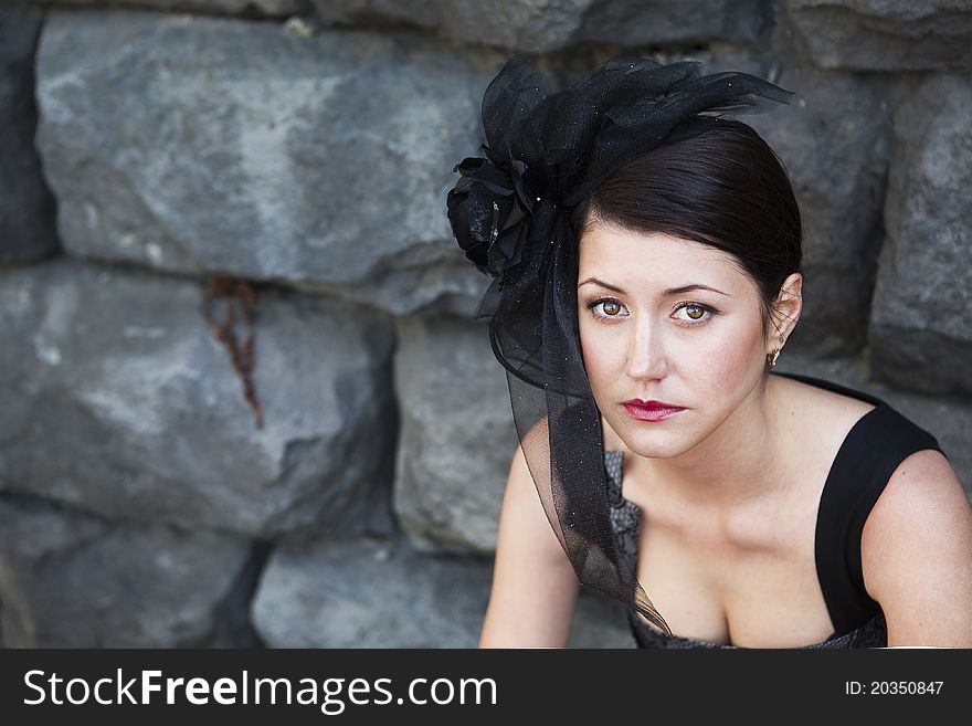 Retro-stylized woman in black hat with veil and black dress.