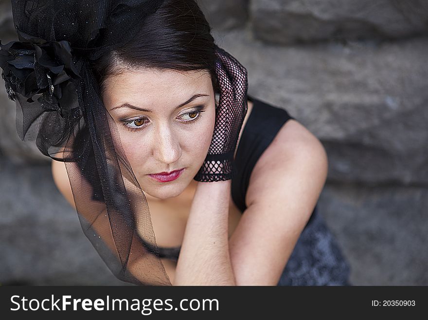 Retro-stylized woman in black hat with veil and black dress.