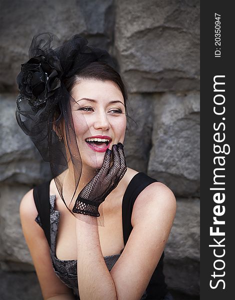 Retro-stylized woman in black hat with veil and black dress.