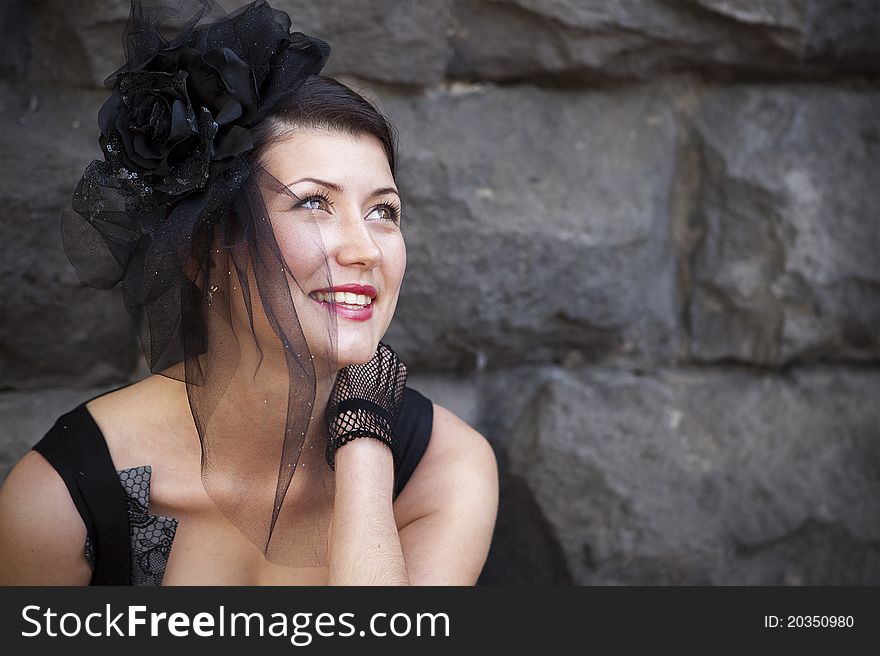 Retro-stylized woman in black hat with veil and black dress.