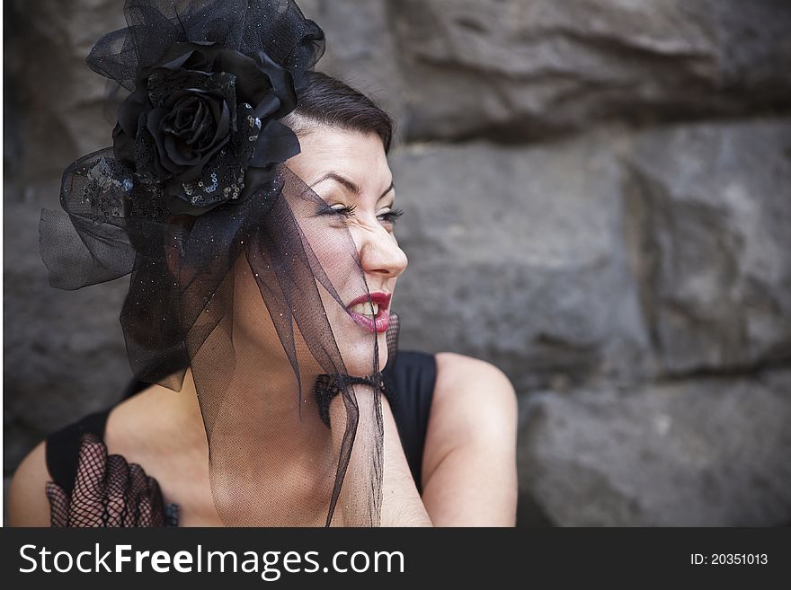 Retro-stylized woman in black hat with veil and black dress.