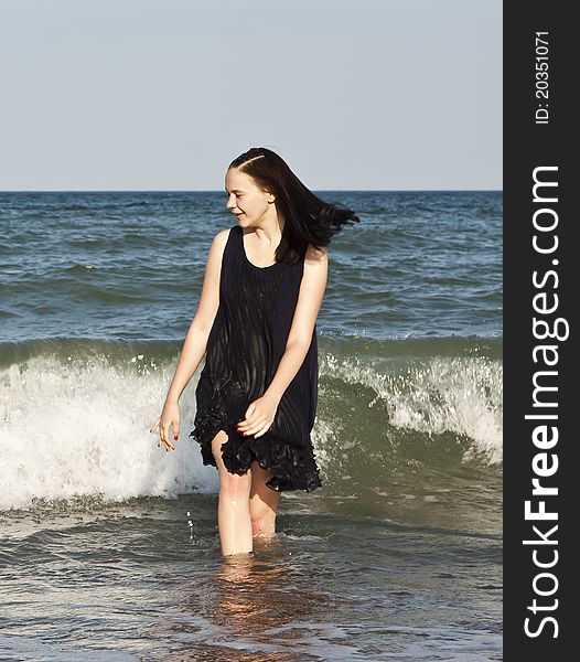 Young brunette in black at the sea