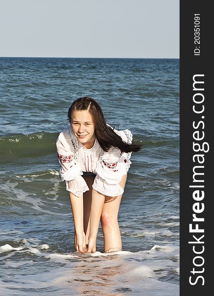 Girl in denim shorts and a t-shirt walks on the beach. Girl in denim shorts and a t-shirt walks on the beach