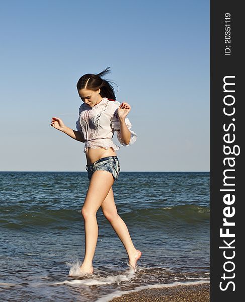 Beautiful woman in shorts running on the beach