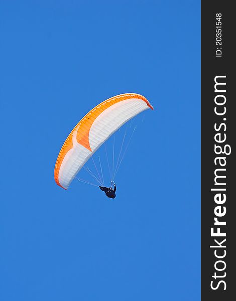Colorful paraglider on blue bright sky. Colorful paraglider on blue bright sky
