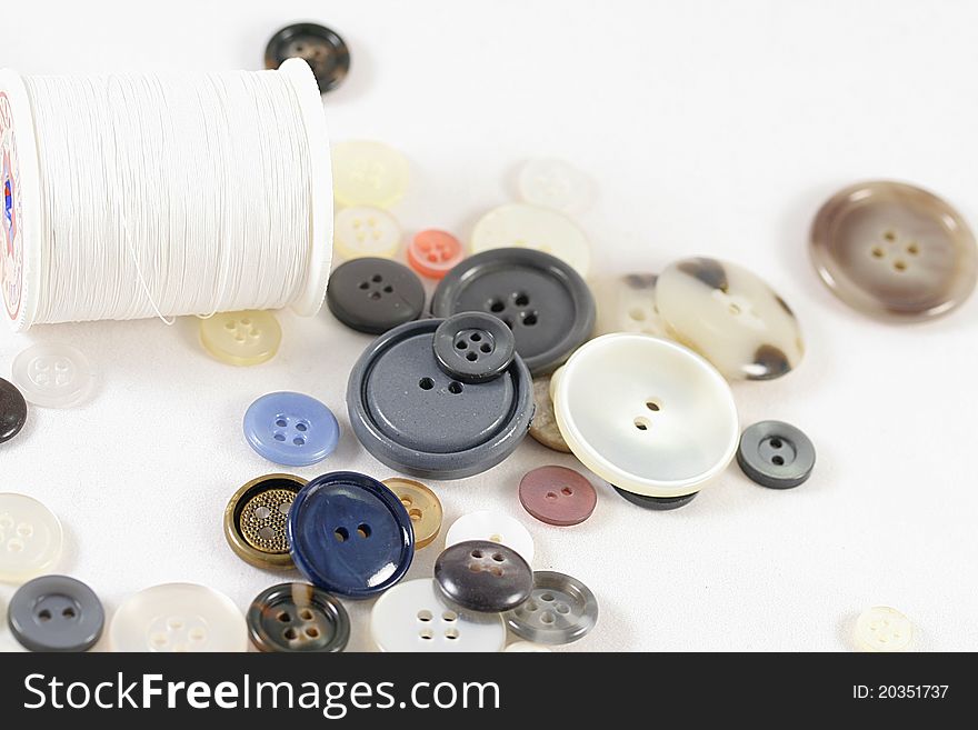 Close up of a handful of buttons with thread.