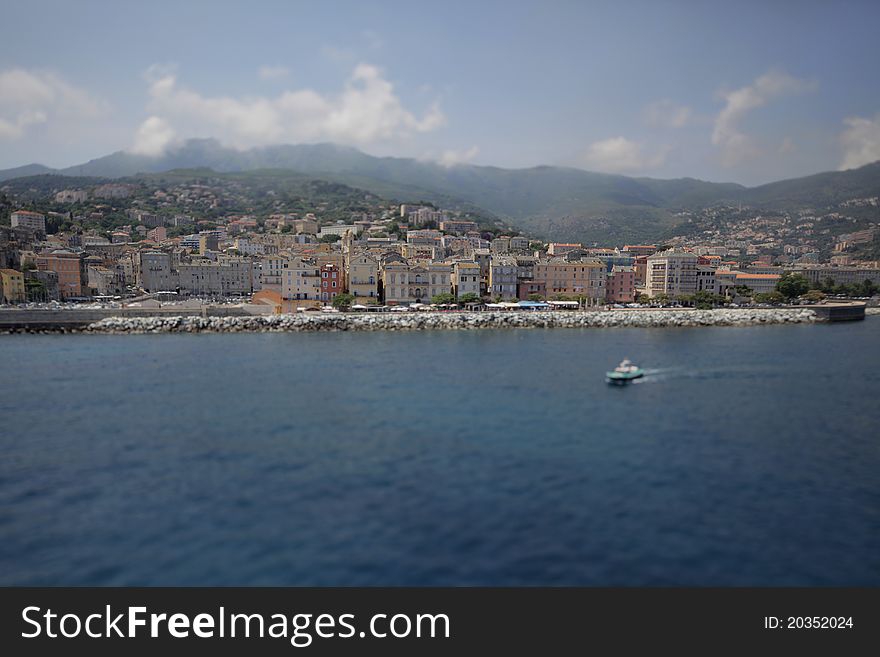 Coastal city with embankment and marina, with a boat