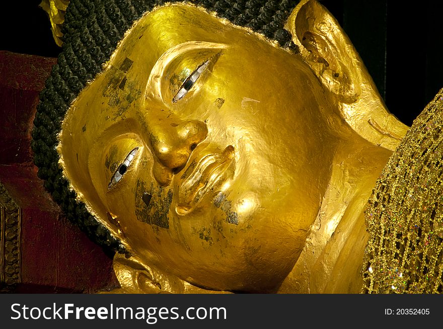 The face of golden buddha in sleeping posture