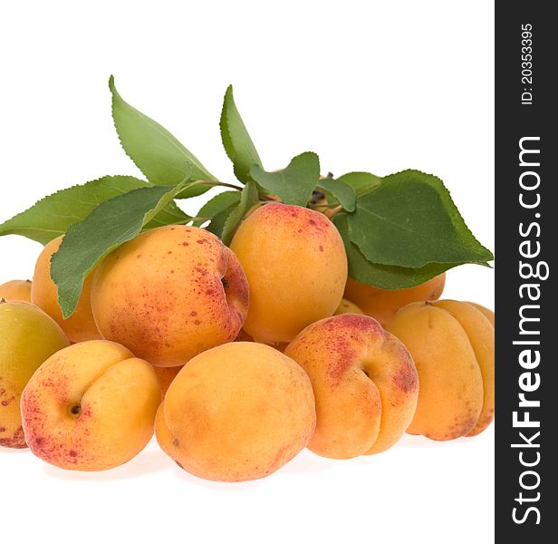 Apricots with a sheet lie a heap on a white background. Apricots with a sheet lie a heap on a white background