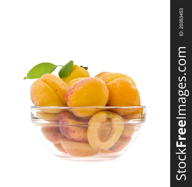Apricots with a sheet it is lied a half  in a dish isolated. Apricots with a sheet it is lied a half  in a dish isolated