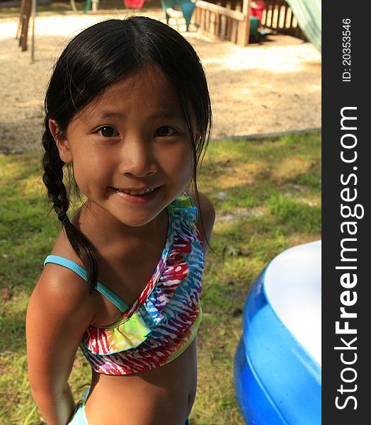 Little asian chinese girl with breads in a bathing suit. Little asian chinese girl with breads in a bathing suit