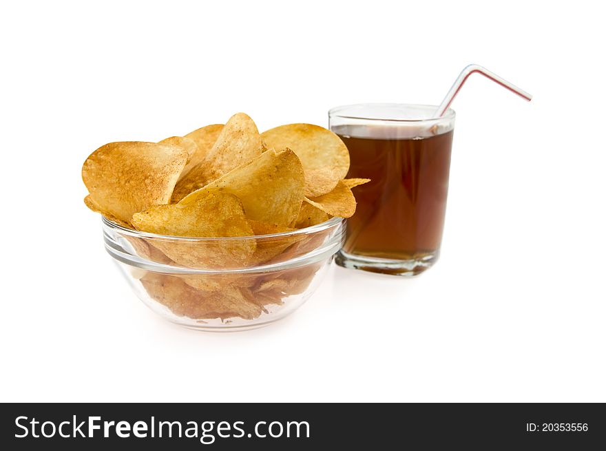 Chips in a dish on a background glass with drink on a white background