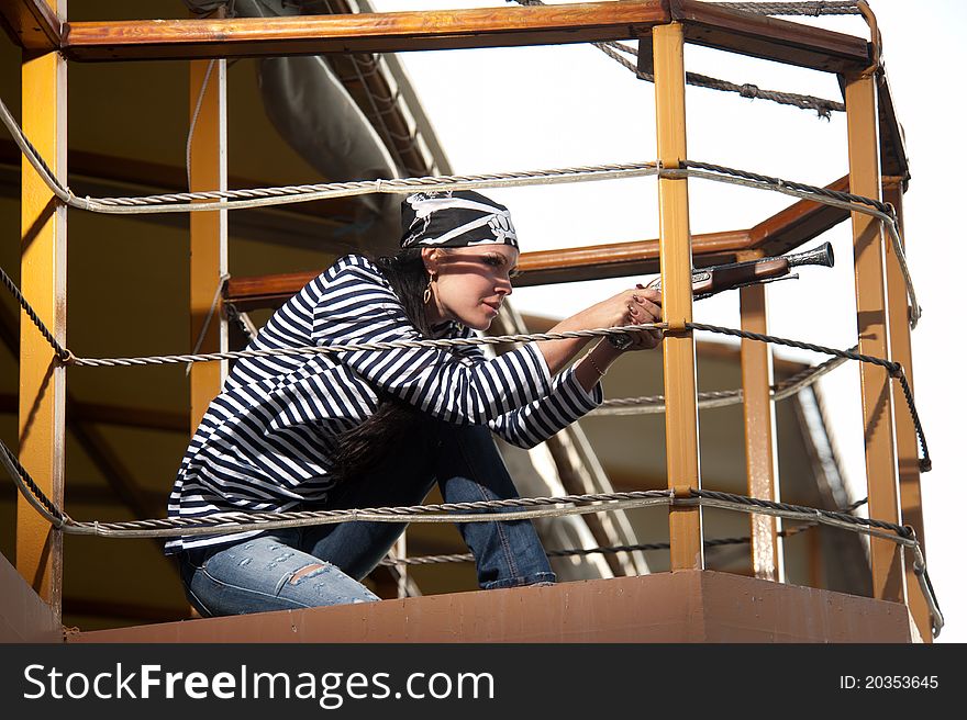 Woman with gun sitting on the deck of a ship