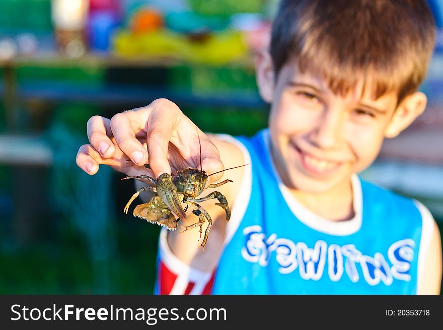 Little boy holding a small cancer. Nature life