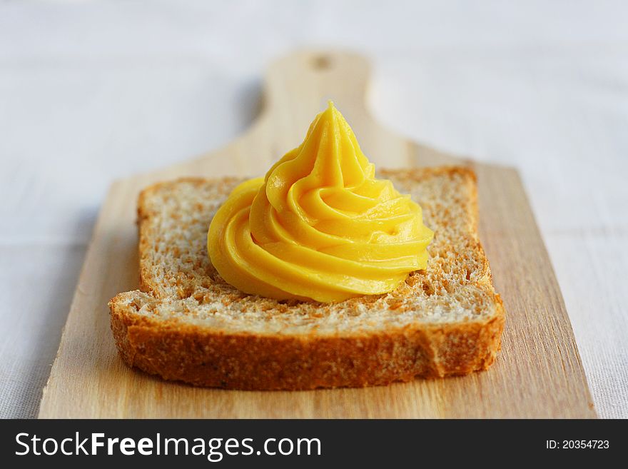 Homemade mayonnaise and a slice of integral bread, on a wood chopping board. Homemade mayonnaise and a slice of integral bread, on a wood chopping board